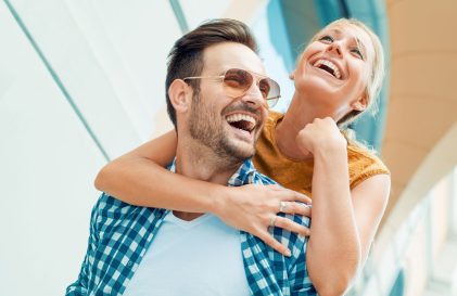 a man holding a woman on his shoulders.